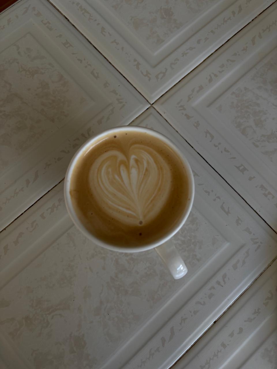 Latte con diseño de corazón sobre azulejo